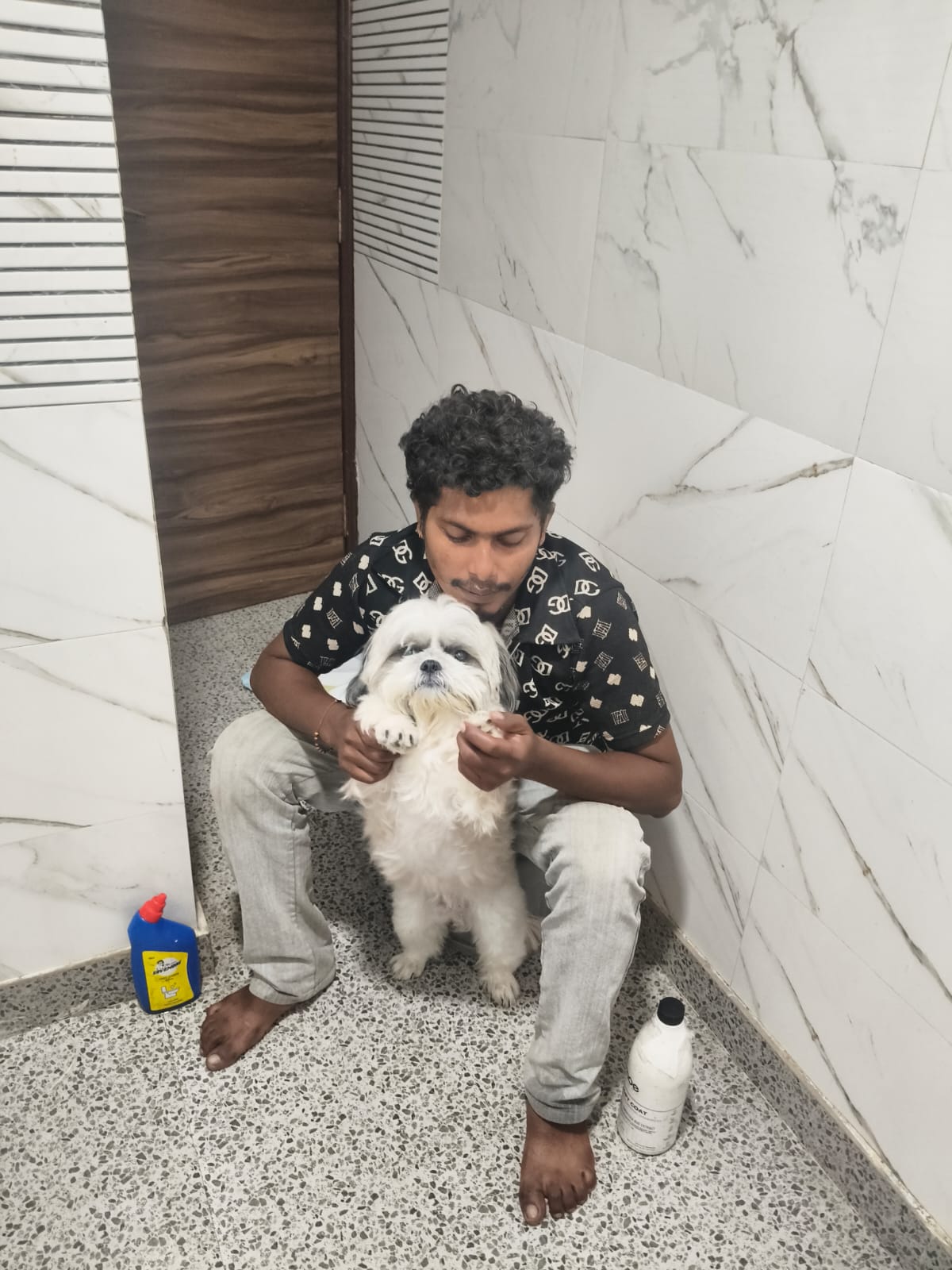 Mantosh gently cuddling and drying freshly bathed white pup